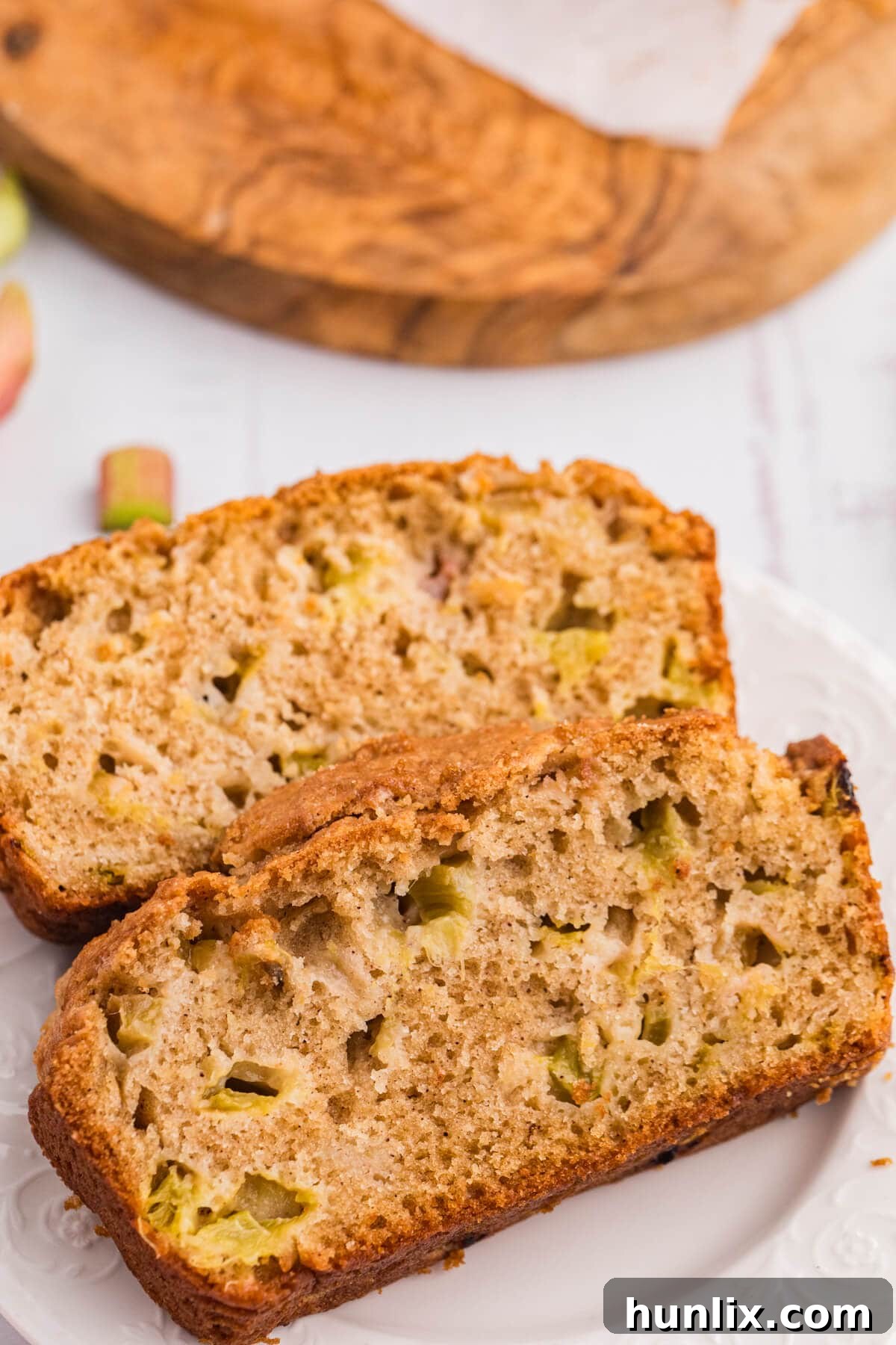 Tangy Rhubarb Loaf 9 Slices of rhubarb bread on a white plate, ready to be served.