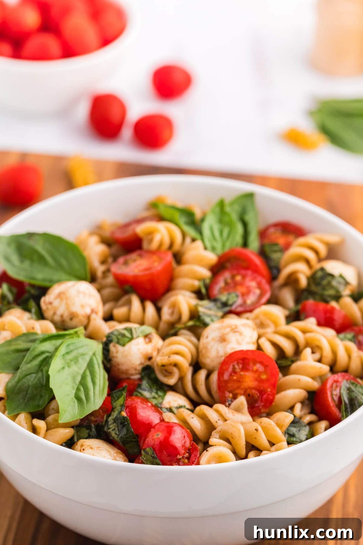 The finished Caprese Pasta Salad in a pristine white bowl, showcasing its vibrant colors and fresh ingredients.
