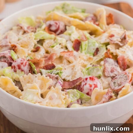 The BLT pasta salad in a white bowl, garnished with fresh herbs.