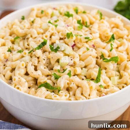 The classic creamy macaroni salad in a white bowl, ready to be served.
