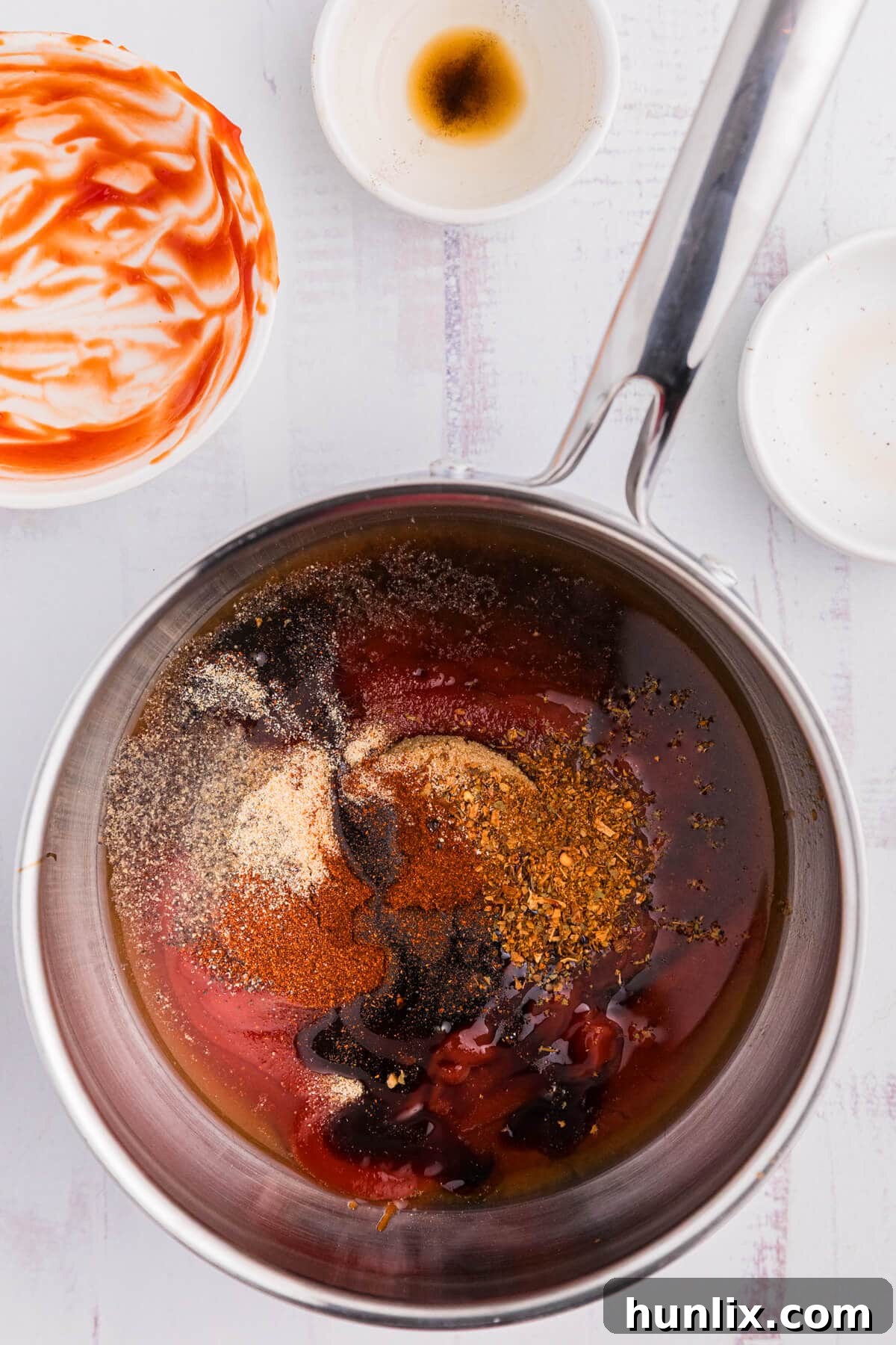 All the sauce ingredients being whisked together in a saucepan.