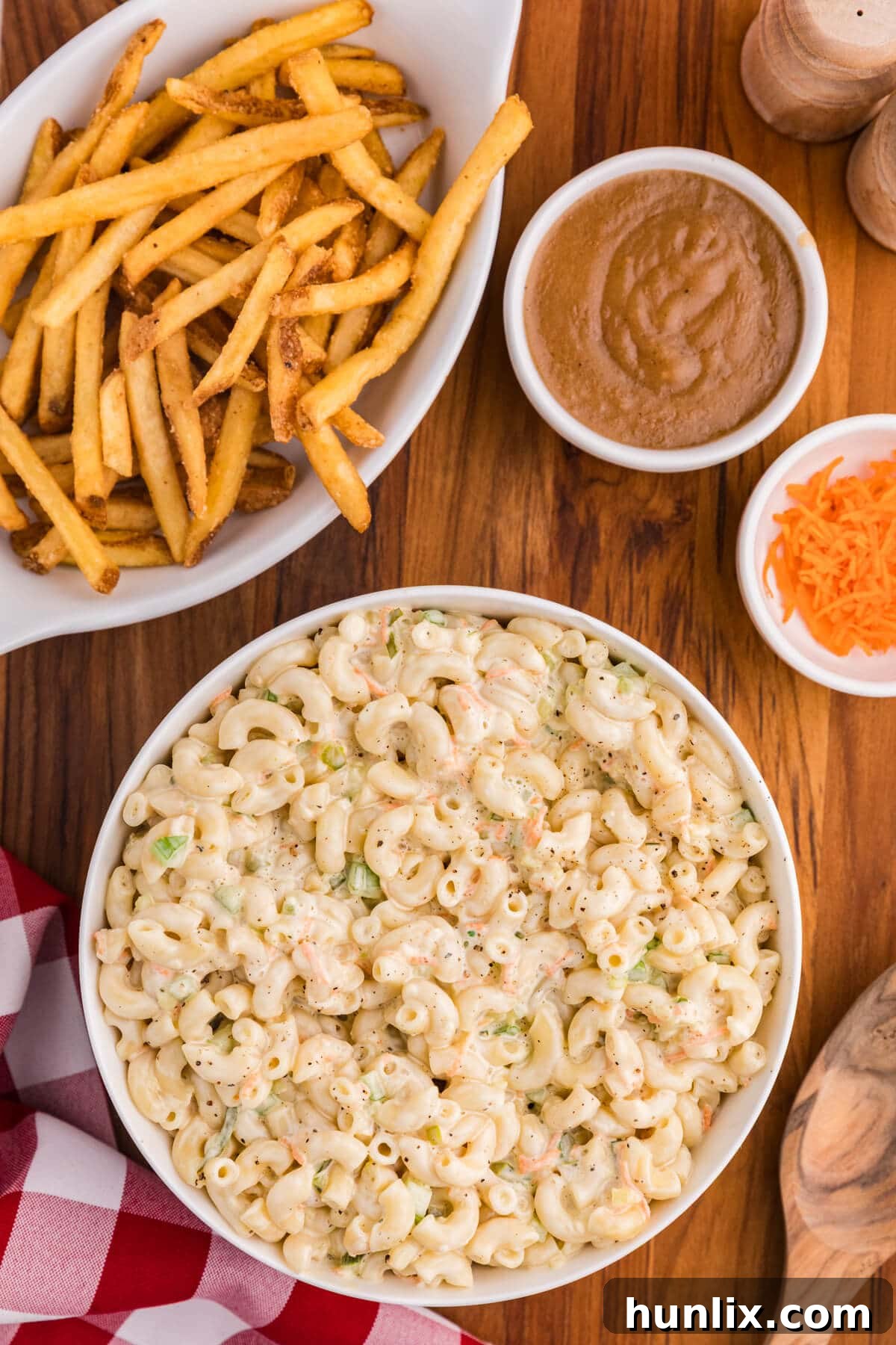 A bowl of copycat KFC macaroni salad with fries and gravy beside it.