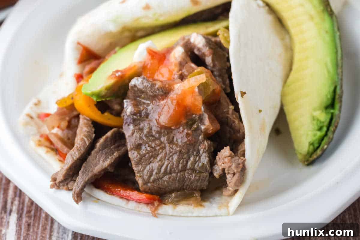 Slow cooker steak fajitas on a plate, ready to be served.