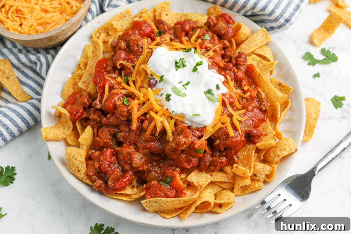 Crockpot Frito Chili Pie, a hearty and classic dish with ground beef, chili, Frito corn chips, and melted cheese.