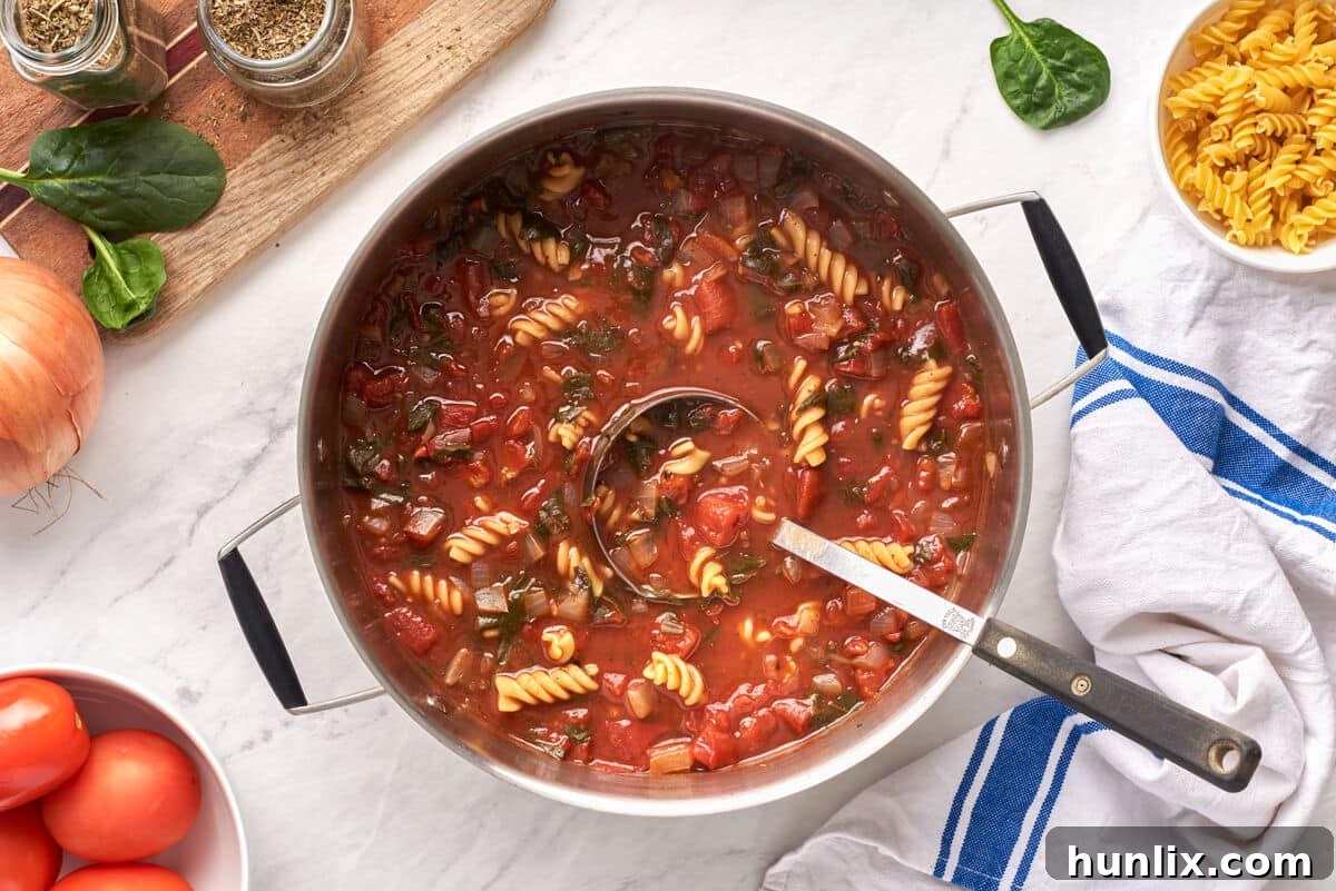 Comfort in a Bowl: Soups and Stews for Cold Days 12 A large pot of vibrant Tomato Florentine Soup with a ladle.