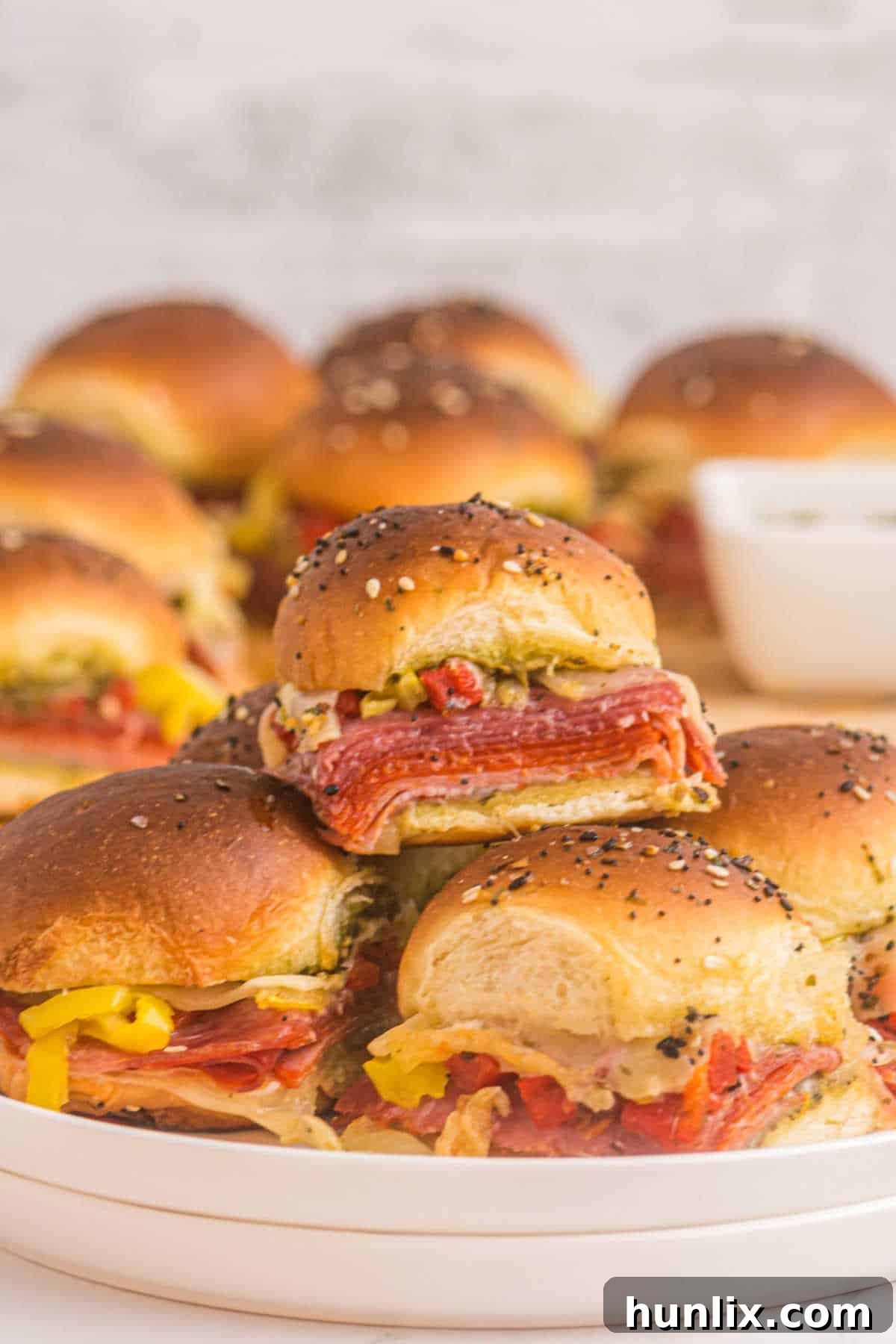 Flavorful Italian sliders layered with meats, cheese, and pesto.