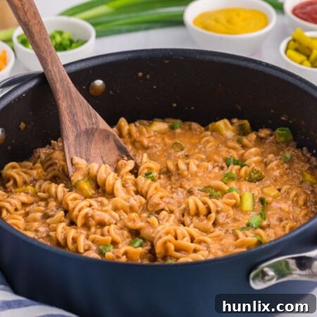 The recipe in a dark pan with a wooden spoon.