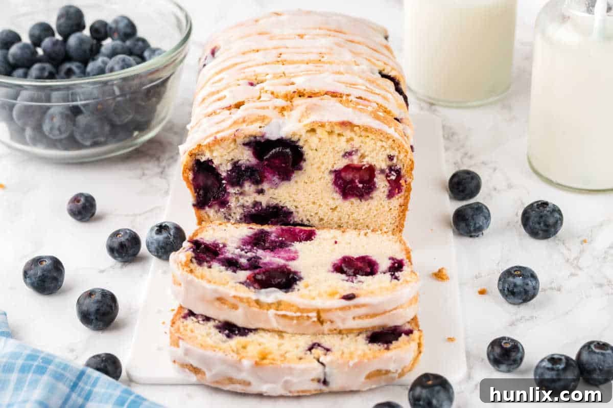 Freshly baked Blueberry Bread with several slices cut off, revealing juicy blueberries.