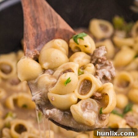 Cheesesteak Noodle Skillet 8 Philly Cheesesteak Pasta served on a wooden spoon.