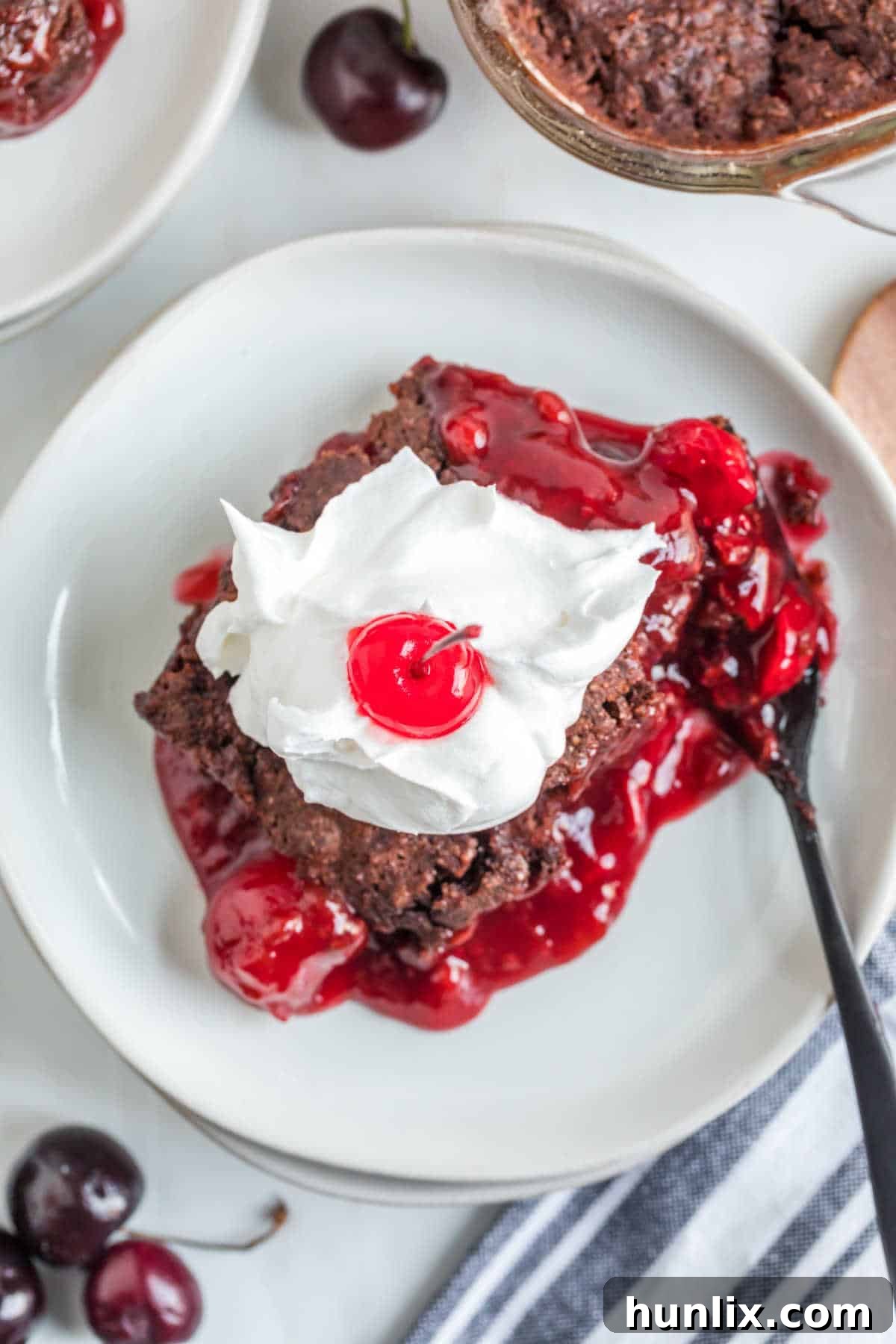 A delectable Black Forest Dump Cake, showcasing its rich chocolate and cherry layers, ready for serving.