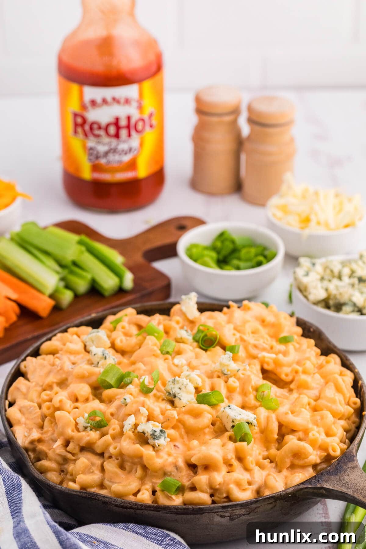A bubbling pan of Buffalo Chicken Mac and Cheese, rich with creamy sauce and golden-brown macaroni, ready to be served.