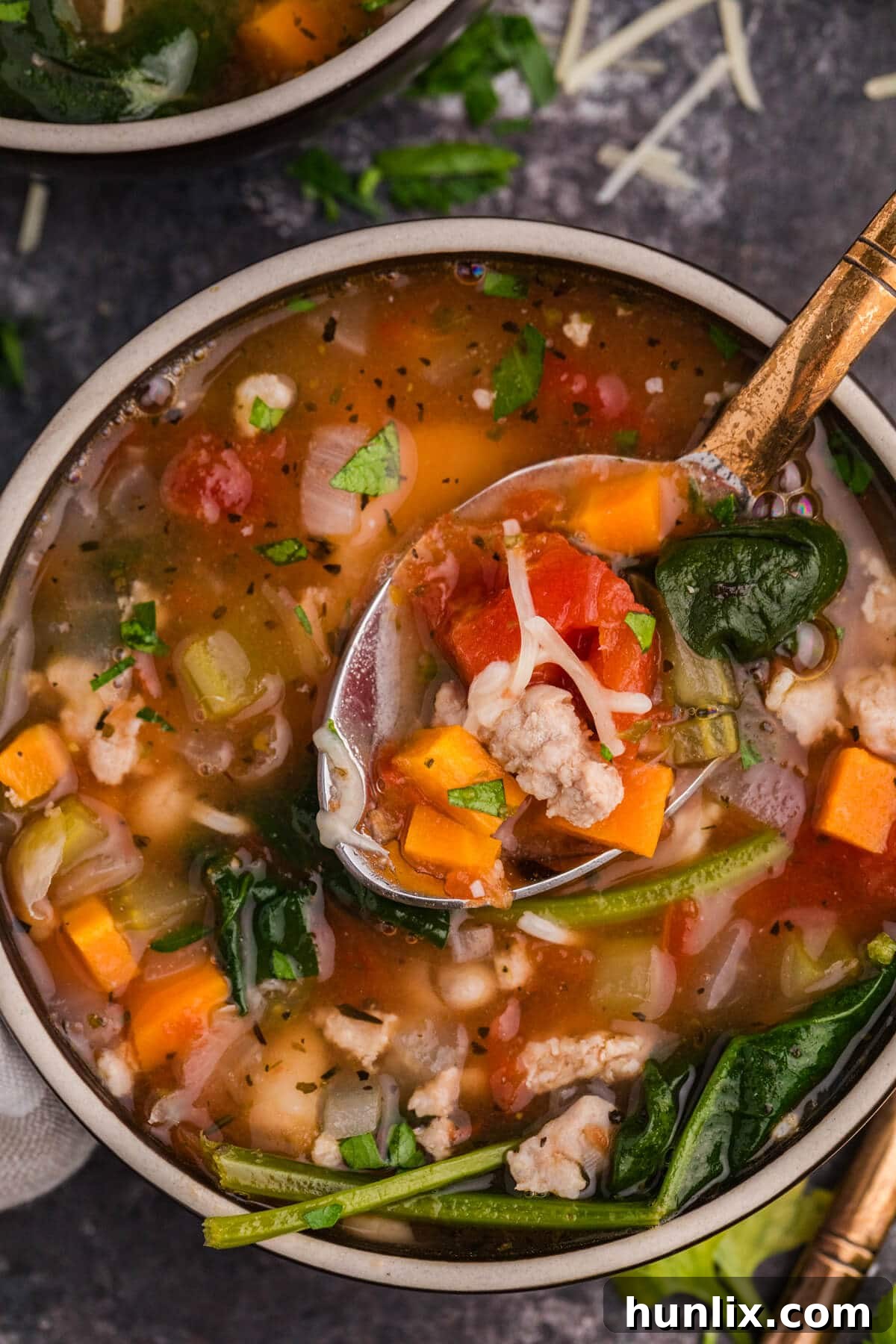 A bowl of the White Bean and Sausage Soup with a spoon.