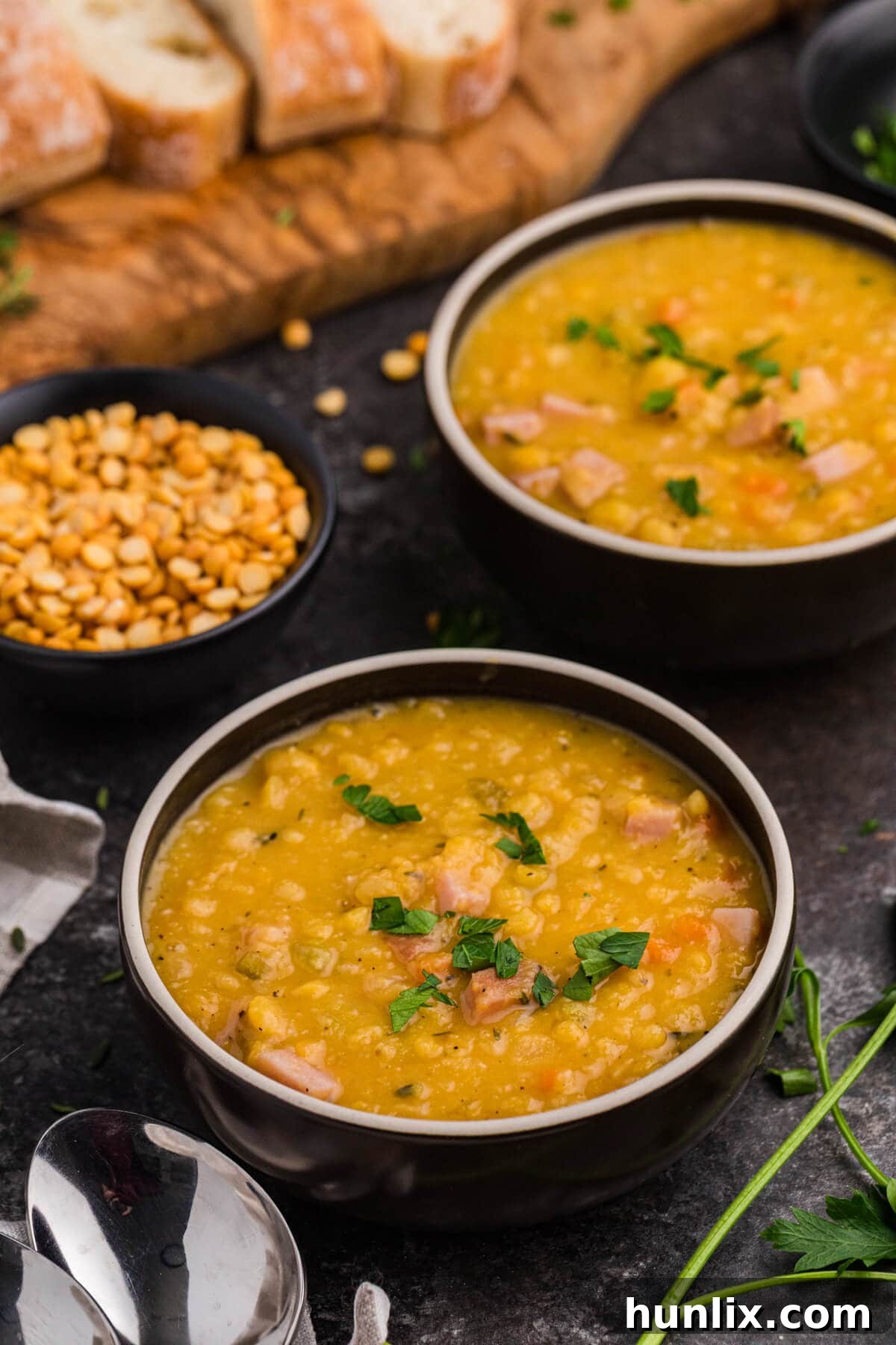 Wholesome Split Pea Warmth 2 A black bowl of delicious homemade split pea soup, garnished with fresh parsley.