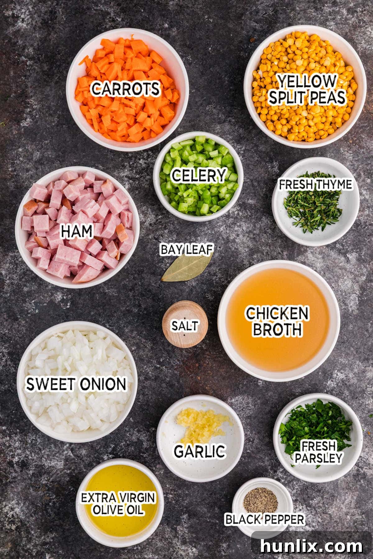 Wholesome Split Pea Warmth 3 Assortment of fresh ingredients for split pea soup, including peas, carrots, celery, onion, garlic, and ham, arranged on a dark background.