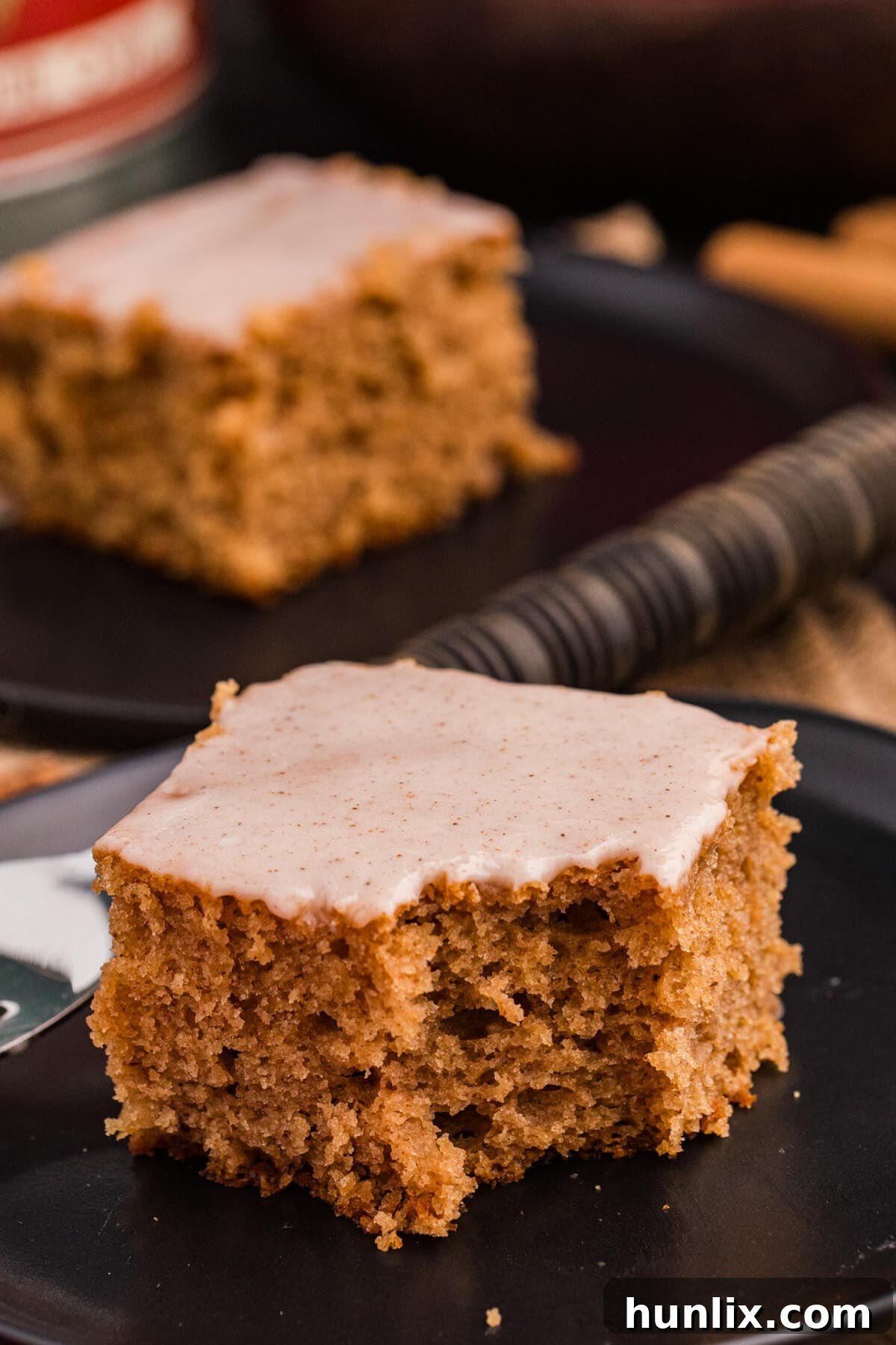 A slice of Apple Butter Cake on a white plate with a bite taken out, showing its light texture.