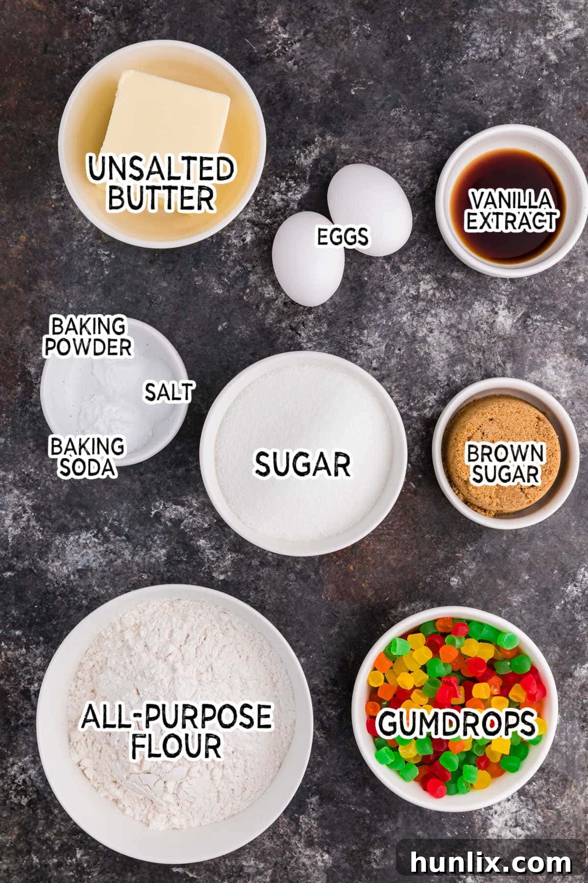 Festive Gumdrop Gems 3 Ingredients for gumdrop cookies displayed on a dark background, including butter, sugars, eggs, vanilla, flour, leavening agents, salt, and colorful gumdrops.