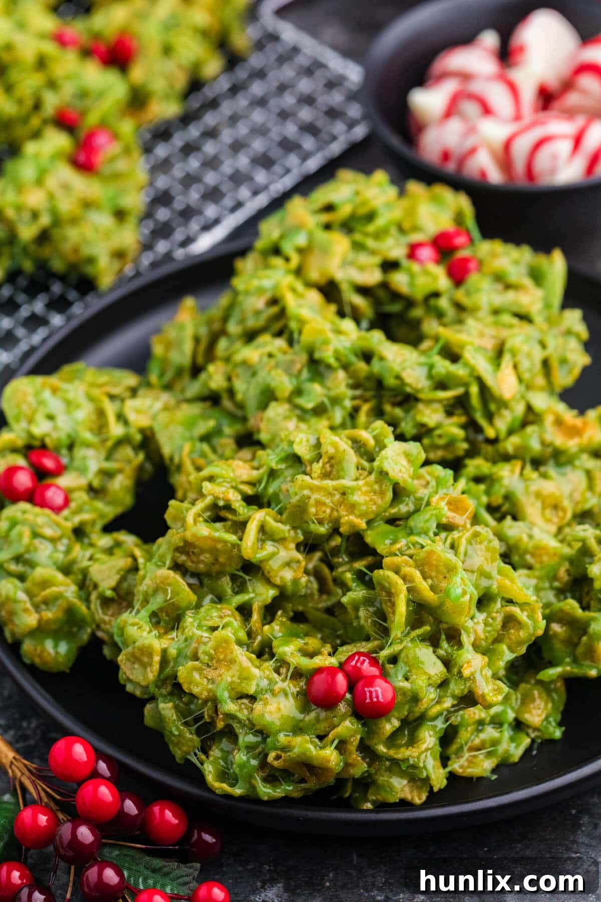 Crispy Cereal Wreaths 2 Cornflake Wreaths made with green marshmallow-coated cornflakes, shaped into holiday wreaths and topped with red candies to resemble holly berries.