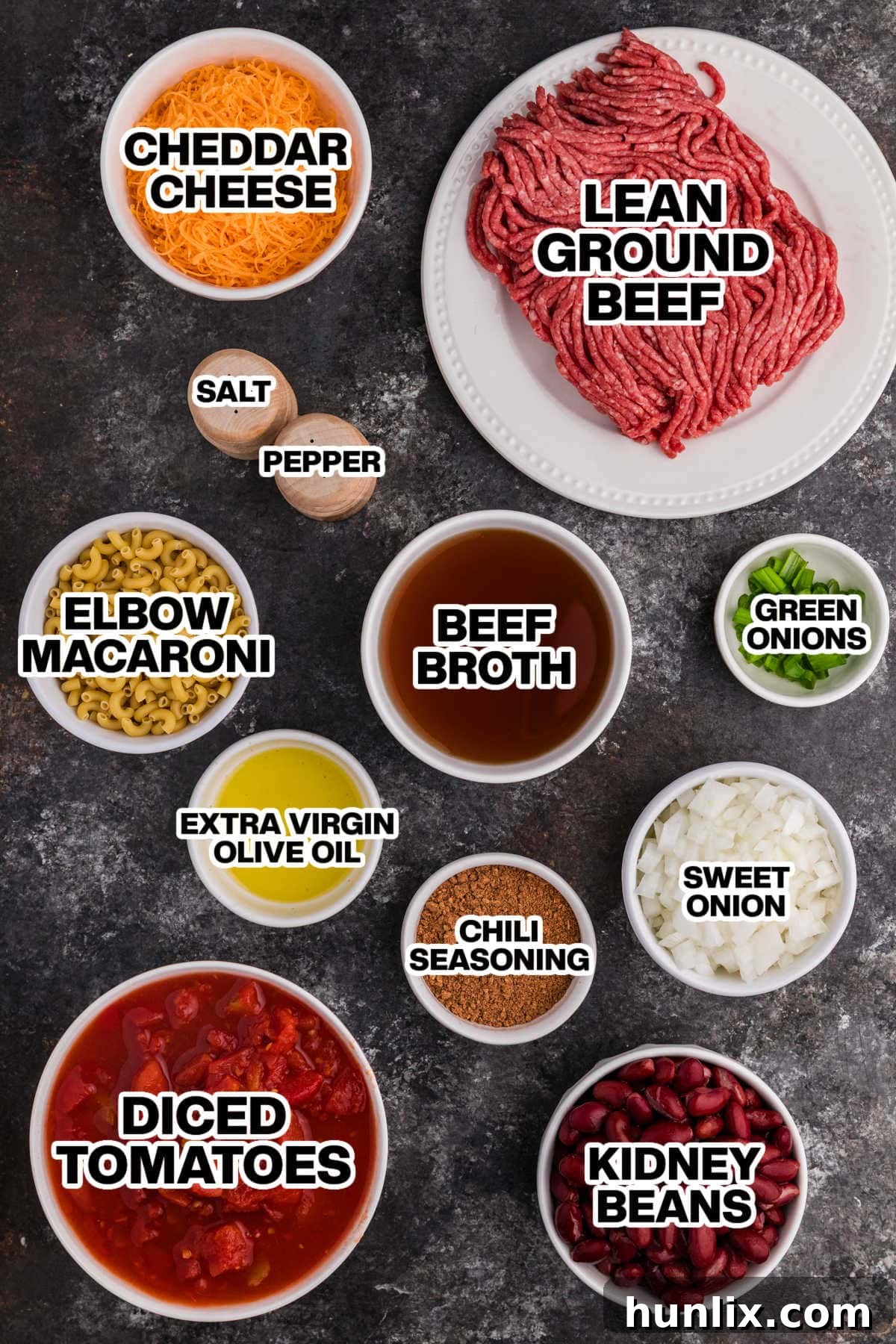 Ingredients for Chili Mac Soup laid out on a dark background.