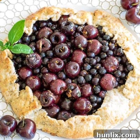 Sweet Saskatoon Cherry Galette with fresh basil and lemon zest, a deliciously lazy shortcut on pie.