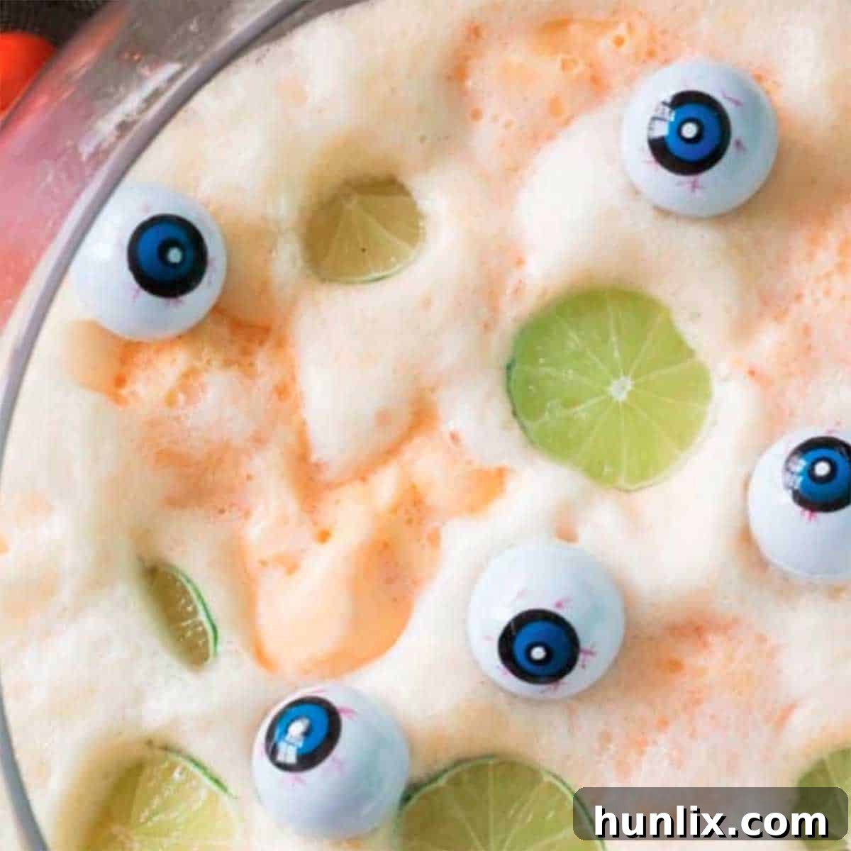 Non-alcoholic Halloween punch with funny eyeballs, orange sherbet, and 7UP.