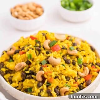 A bowl of flavorful Jamaican Curried Rice with a spoon.
