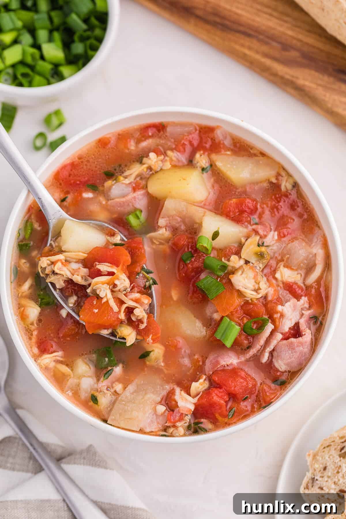 Manhattan Tomato Clam Chowder 8 A bowl of the chowder with a spoon.