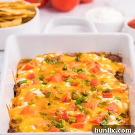 Taco casserole in a white casserole dish, garnished with fresh cilantro.