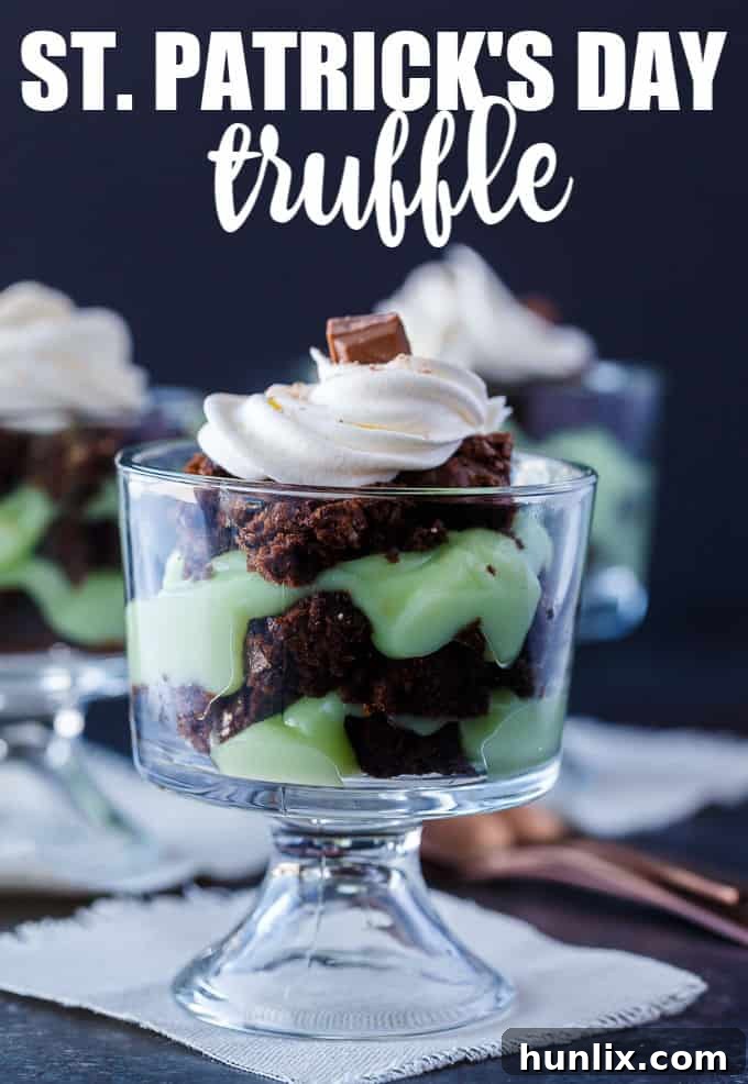 A vibrant green and brown layered St. Patrick's Day Truffle dessert in a glass, topped with whipped cream and chocolate shavings.