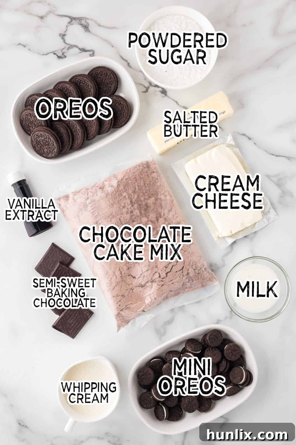 Various ingredients for making Oreo cupcakes, including chocolate cake mix, semi-sweet chocolate, whipping cream, cream cheese, butter, milk, vanilla, powdered sugar, and Oreo cookies, neatly arranged on a white marble background.