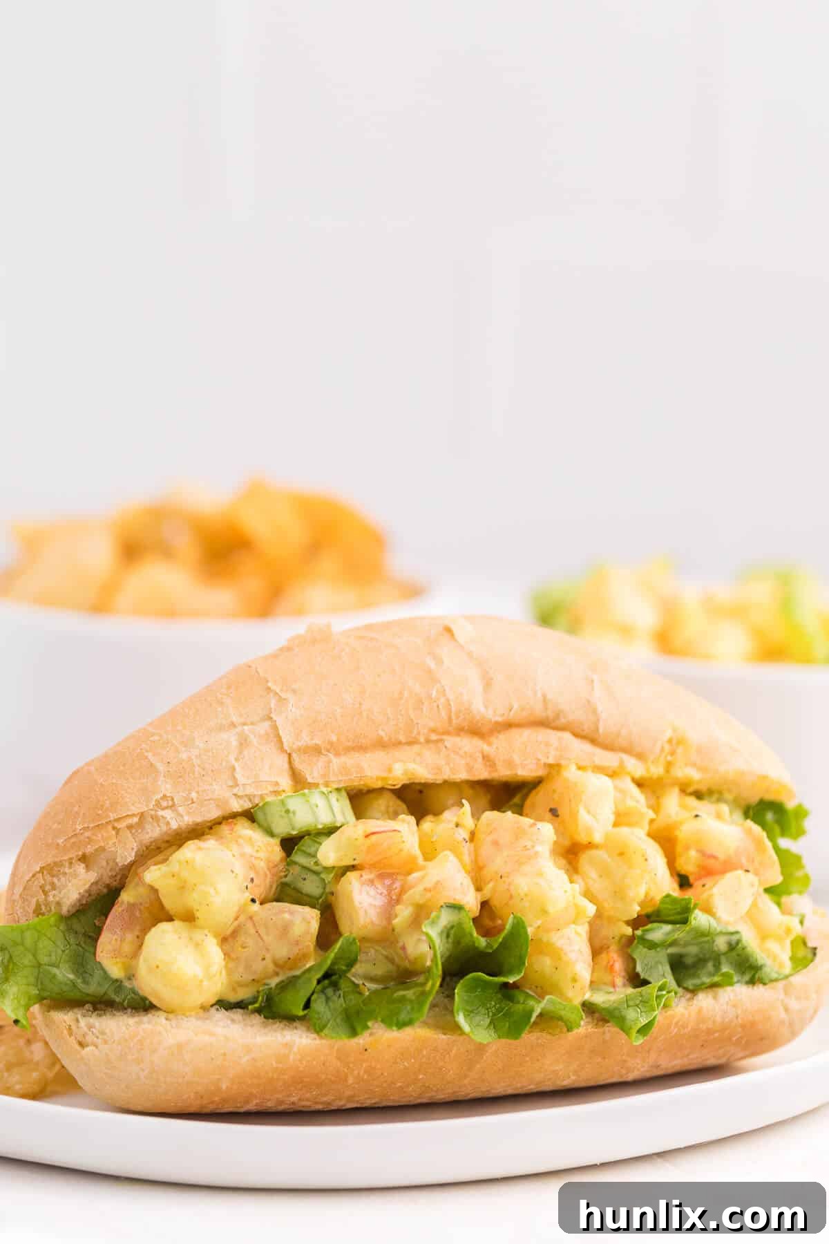 Single Curried Shrimp Roll elegantly presented on a plate, showcasing the vibrant filling and soft bun.
