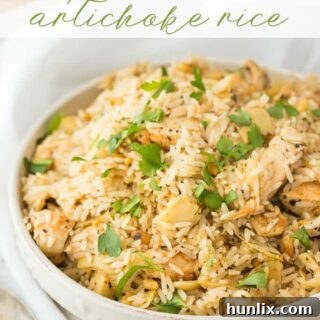 A vibrant close-up of Chicken and Artichoke Rice, garnished with fresh parsley and lemon, showcasing tender chicken, fluffy rice, and succulent artichoke hearts.