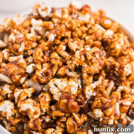 A vibrant close-up of Maple Almond Popcorn in a bowl, showing the perfect coating and crunchy almonds.