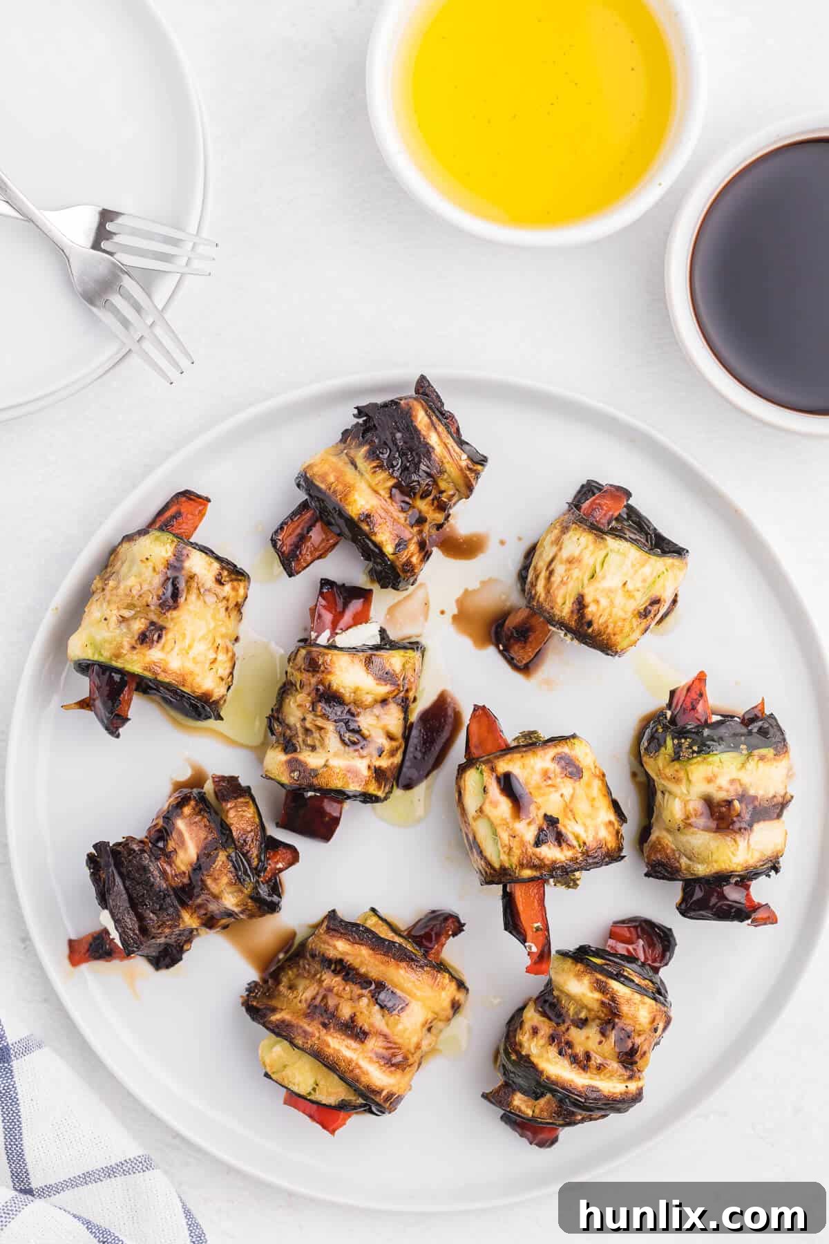 Delectable Grilled Zucchini Roll-Ups 2 Grilled Zucchini Roll-Ups - A simple, but savory summer appetizer. This easy recipe wraps grilled zucchini strips around herbed goat cheese and grilled red peppers with a finish of extra olive oil and balsamic vinegar. Mmm!