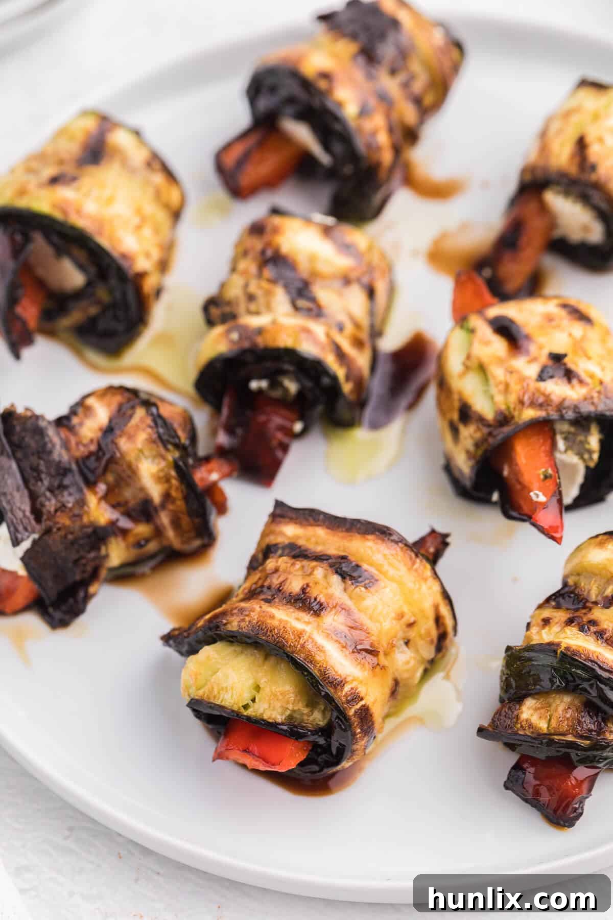 Delectable Grilled Zucchini Roll-Ups 4 Grilled Zucchini Roll-Ups - A simple, but savory summer appetizer. This easy recipe wraps grilled zucchini strips around herbed goat cheese and grilled red peppers with a finish of extra olive oil and balsamic vinegar. Mmm!