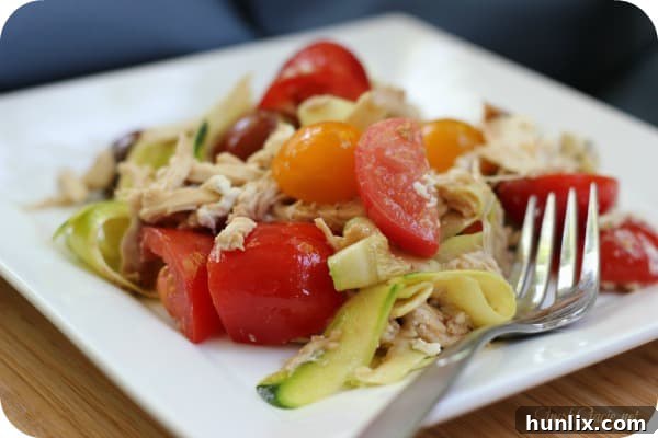 Creamy Zucchini "Pasta" with Tomato - Ditch the carbs with this keto-friendly recipe! These zoodles are fresh and light with tomatoes, shredded chicken, goat cheese, and balsamic vinegar. Perfect for cookouts.