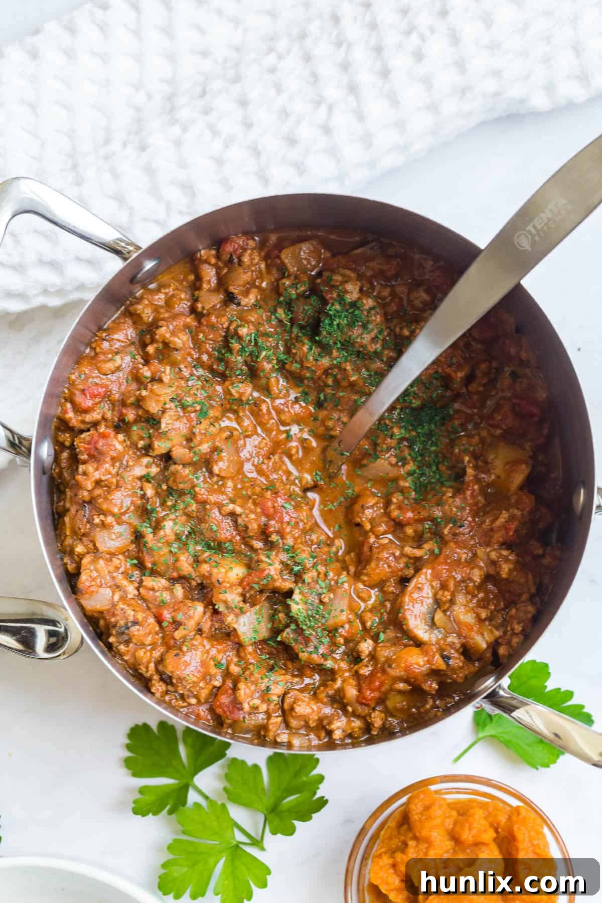 Golden Harvest Pumpkin Chili 2 Pumpkin chili simmering in a large pot, ready to be served with a ladle.