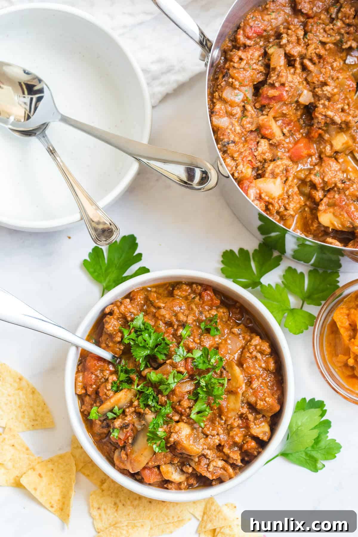 Golden Harvest Pumpkin Chili 7 A close-up shot of pumpkin chili in a rustic bowl with a spoon, showing its thick and inviting texture.