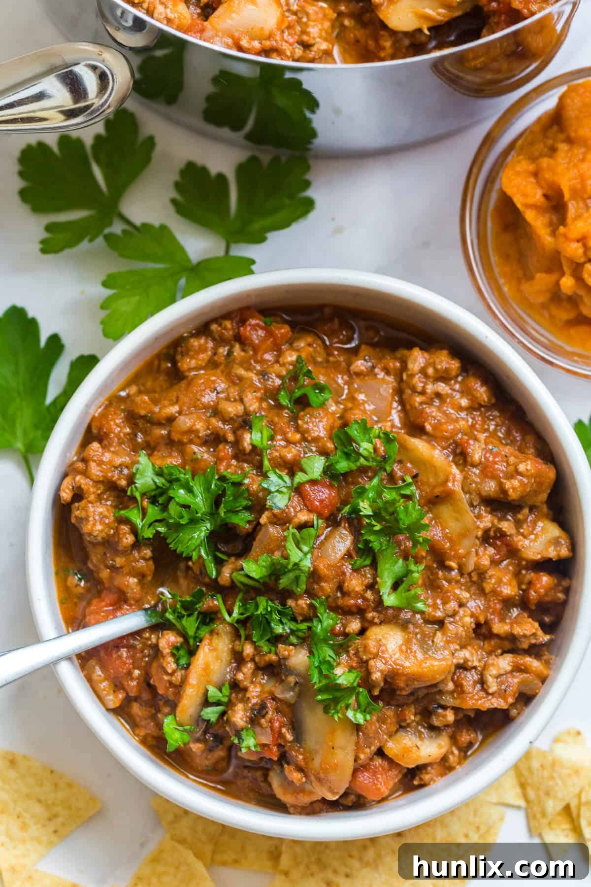 Golden Harvest Pumpkin Chili 8 A serving of pumpkin chili in a bowl with a spoon, highlighting its inviting texture.
