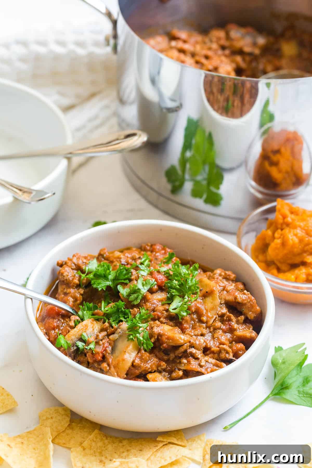 Golden Harvest Pumpkin Chili 9 A pristine white bowl overflowing with rich pumpkin chili, invitingly presented.