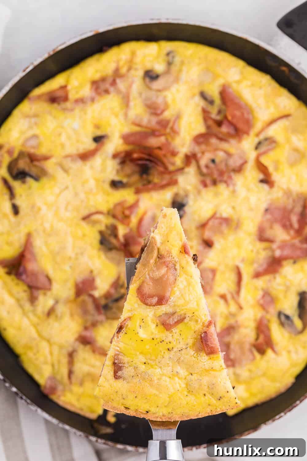 Hearty Turkey Bacon Frittata 4 A nonstick skillet on the stove with sautéed onions and mushrooms, ready for the turkey bacon and egg mixture for the frittata.