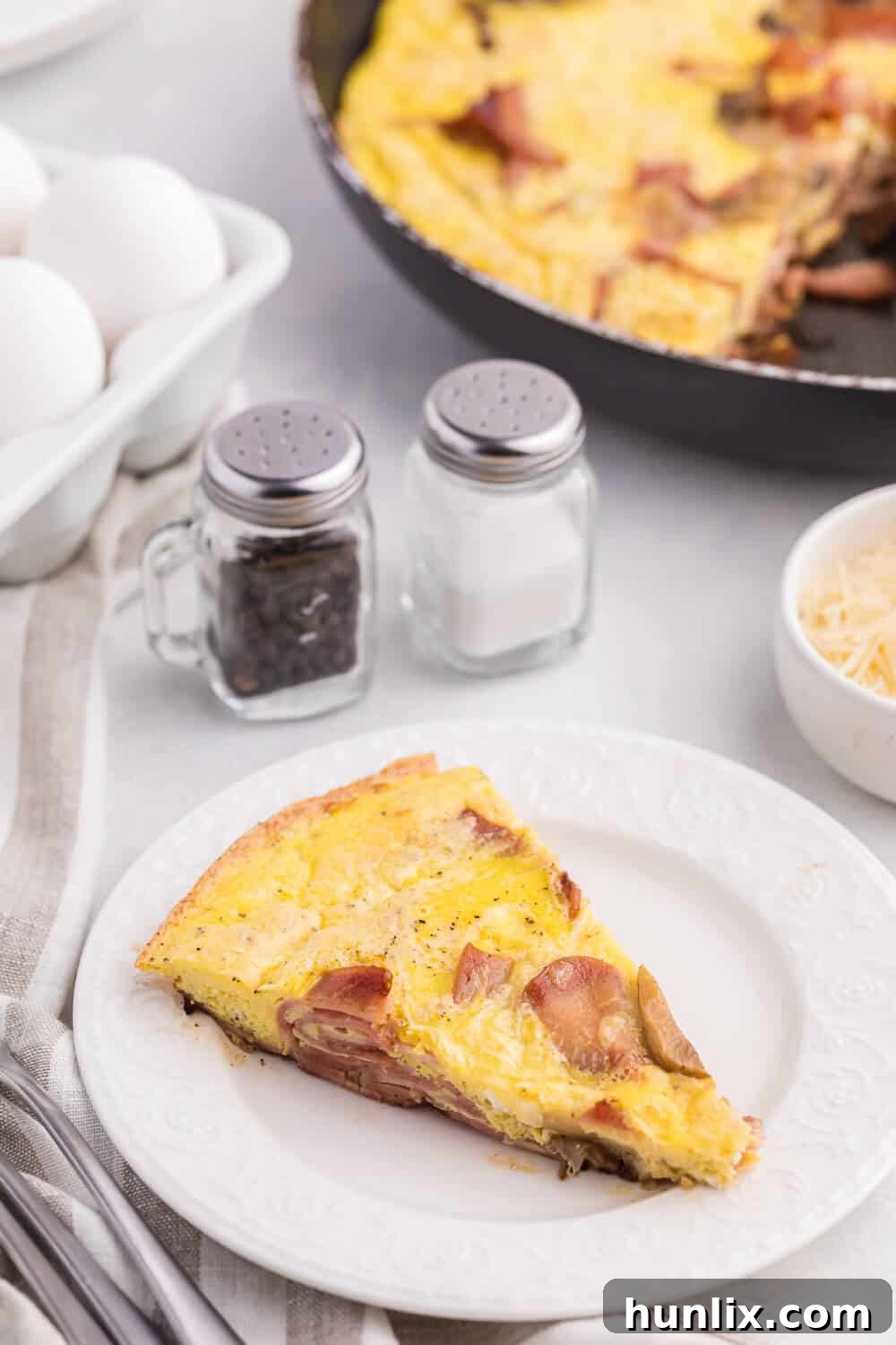 Hearty Turkey Bacon Frittata 5 A freshly baked Turkey Bacon Frittata, golden brown and puffed, cooling in an oven-safe skillet, ready to be sliced and served.