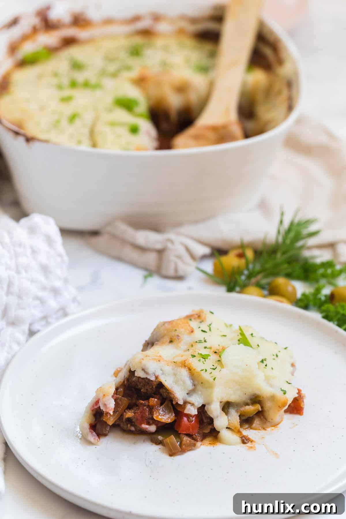 A single serving of Beef Picadillo Shepherd's Pie on a white plate, ready to be enjoyed.