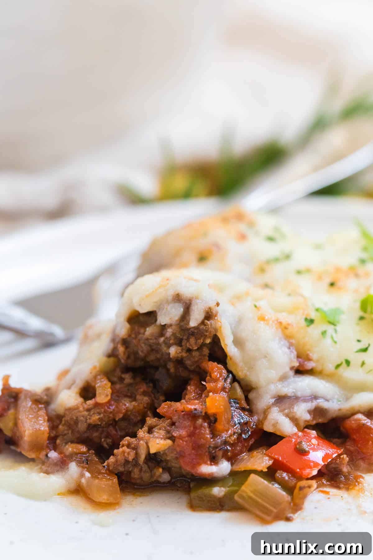 A generous serving of Beef Picadillo Shepherd's Pie on a white plate, highlighting its comforting appearance.