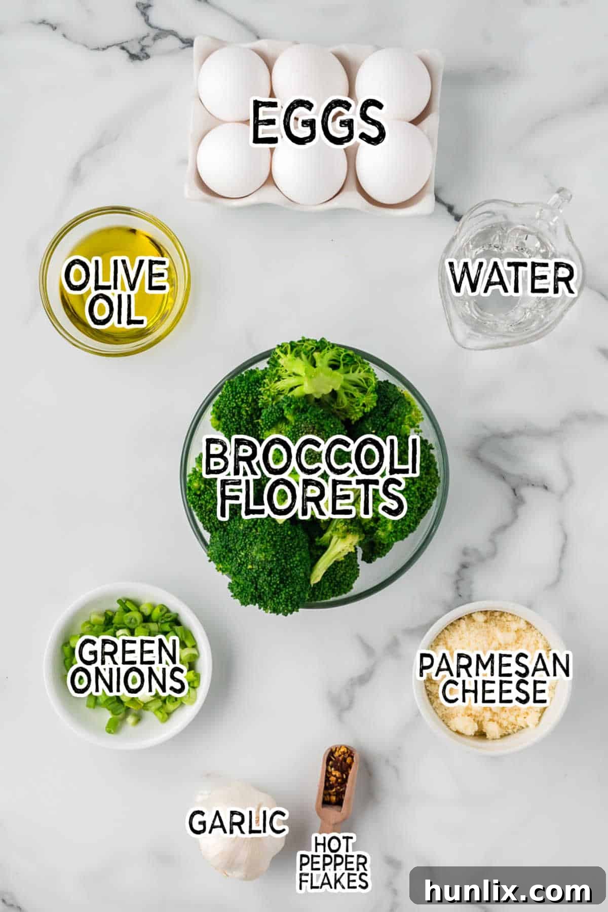 Savory Broccoli Frittata 3 Fresh ingredients laid out on a wooden board, including vibrant broccoli florets, whole garlic cloves, green onions, and a bowl of grated Parmesan cheese.