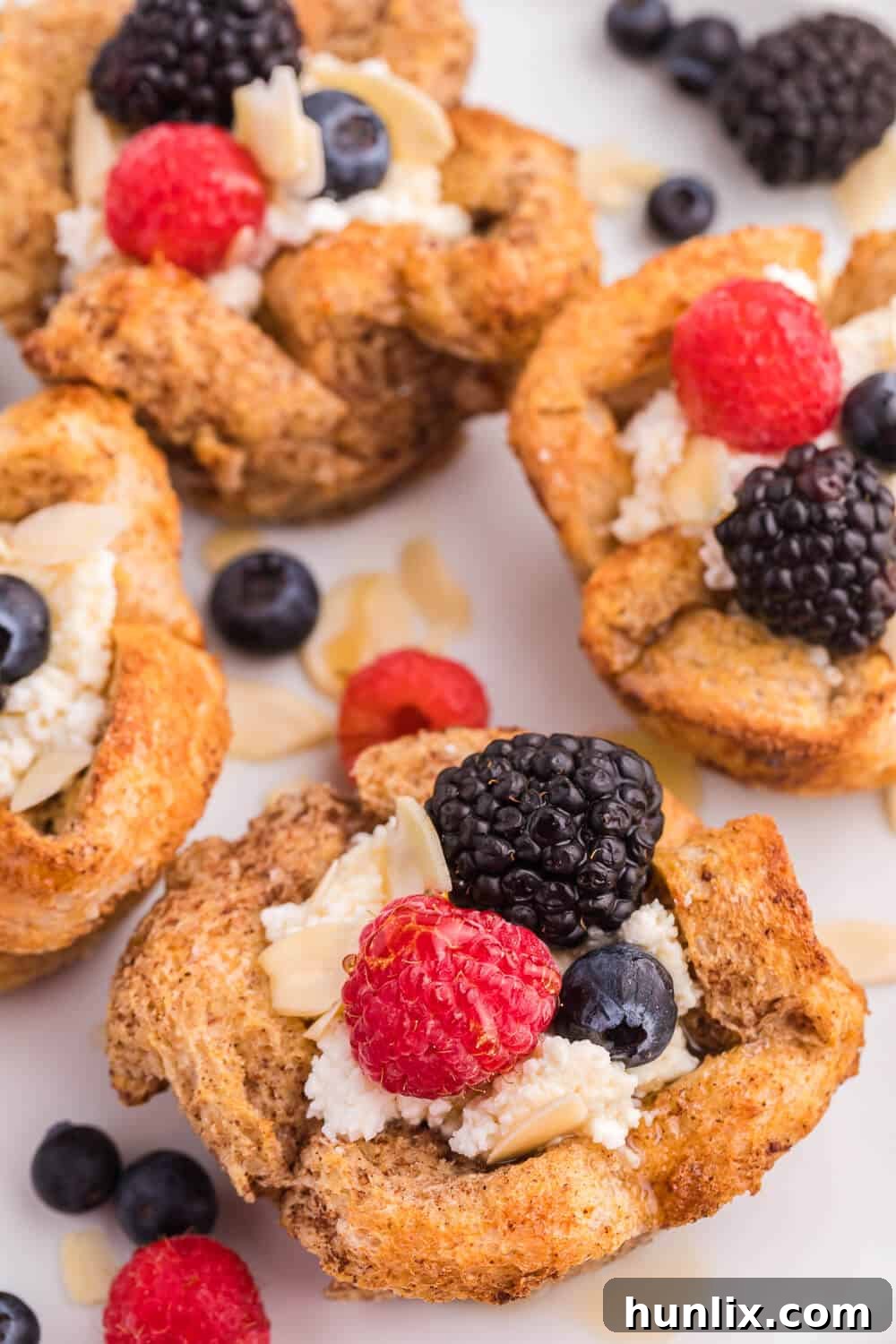 Close-up of French Toast Cups baked to golden perfection in a muffin tin, ready for toppings.