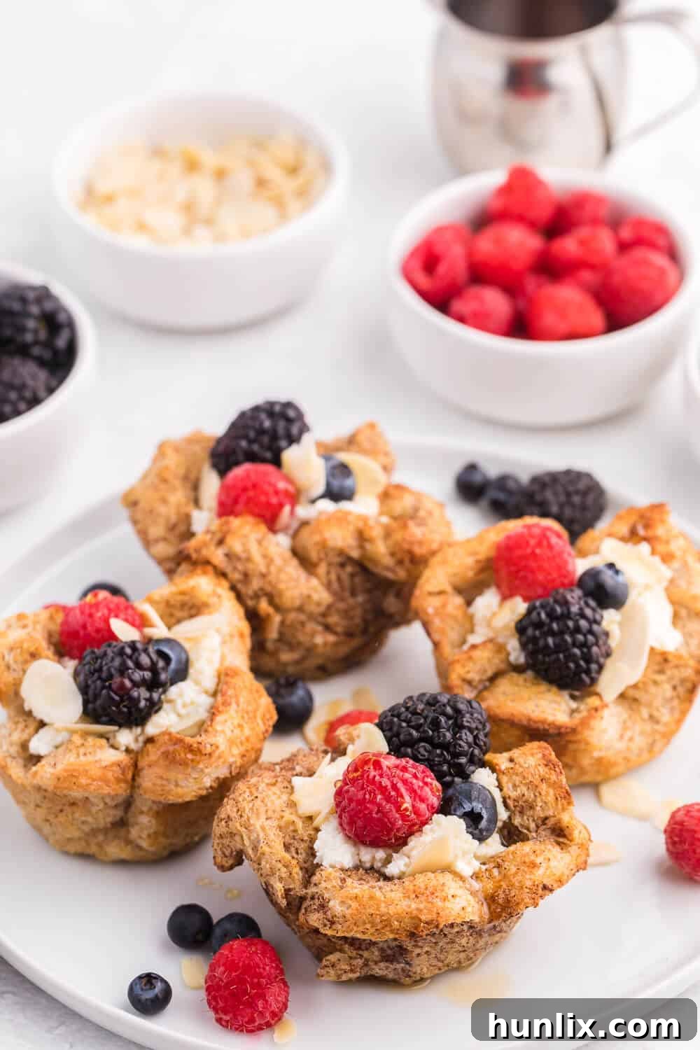 Freshly baked French Toast Cups topped with a generous dollop of ricotta, a colorful assortment of mixed berries, and a sweet honey drizzle.