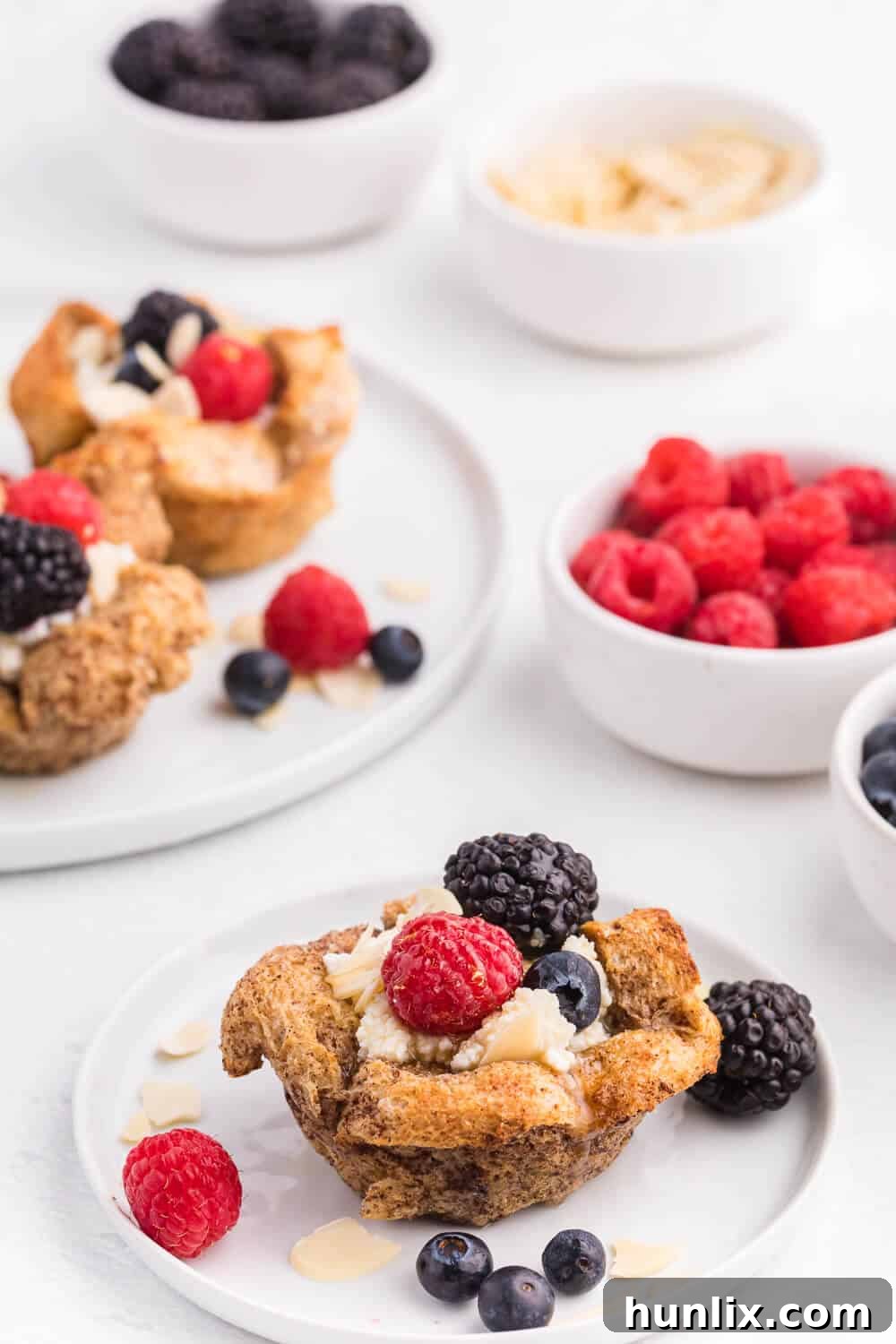 A top-down view of French Toast Cups arranged elegantly, showcasing the vibrant colors of fresh berries and a golden drizzle of syrup.