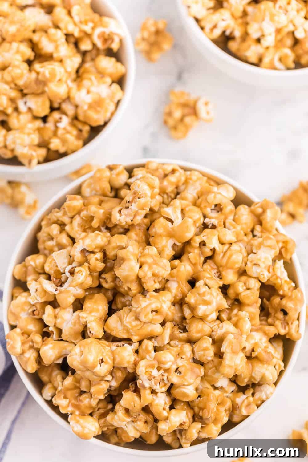 Three bowls of caramel marshmallow popcorn, ready to be enjoyed.