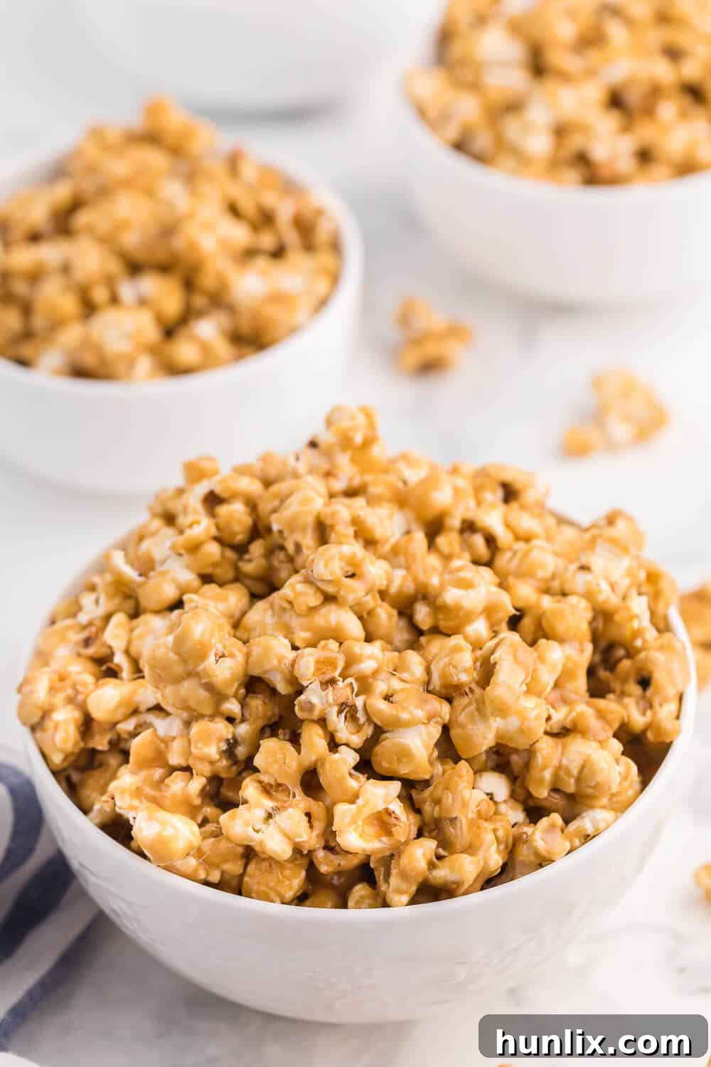 Three white bowls of delicious caramel marshmallow popcorn.