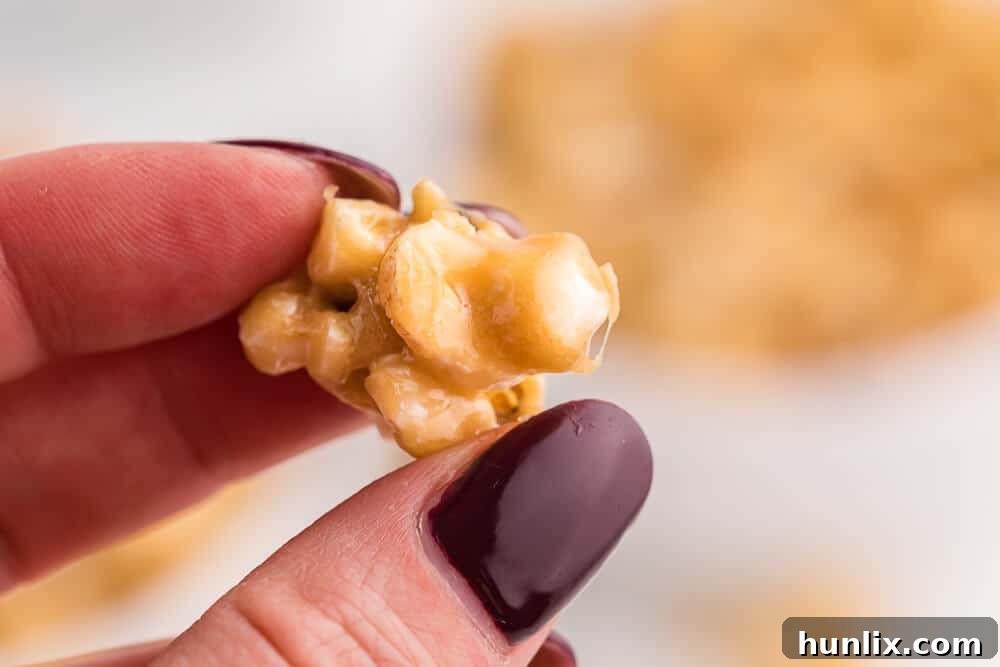A hand reaching into a bowl of caramel marshmallow popcorn.